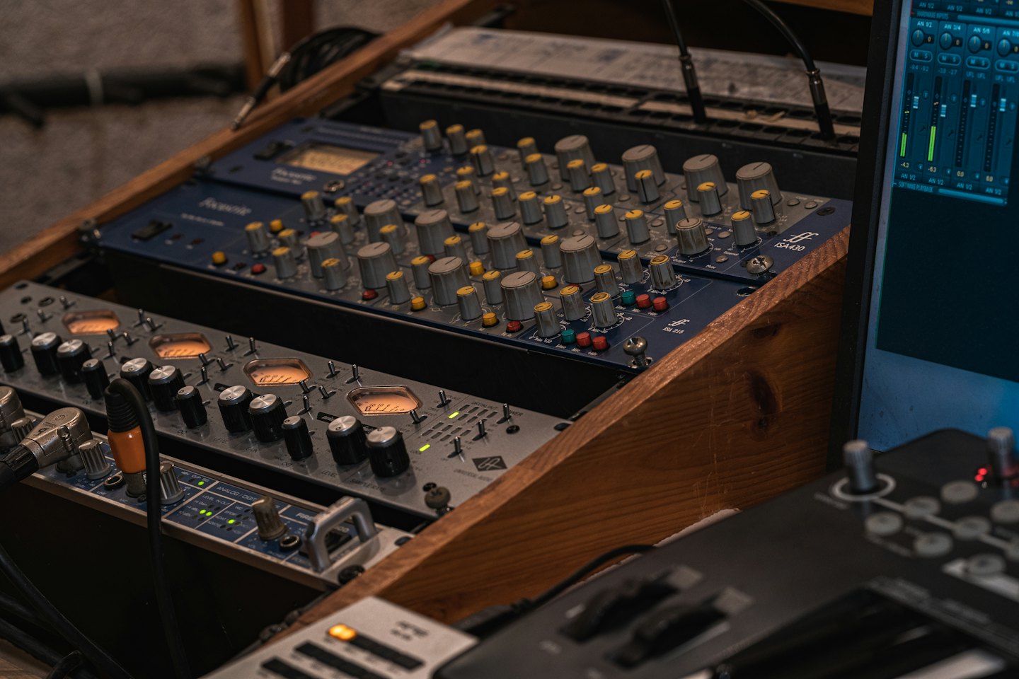 Professional audio mixing equipment sits inside a wooden rack.